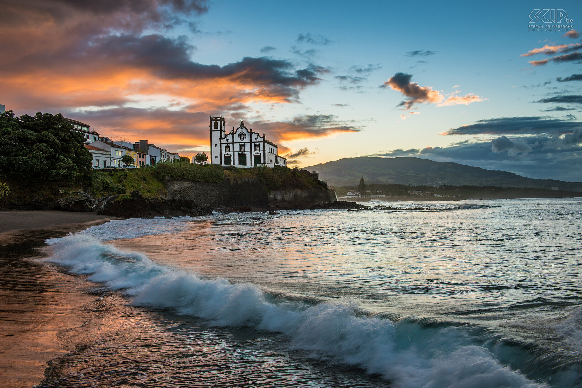 Zonsopgang Sao Roque Een prachtige zonsopgang op het zwarte zandstrand van São Roque met op de achtergrond kerk. São Roque is een deelgemeente van Ponta Delgada, de administratieve hoofdstad van de Azoren. De prachtige witte kerk (ingreja) van São Roque ligt hoog boven de oceaan tussen 2 stranden. Stefan Cruysberghs